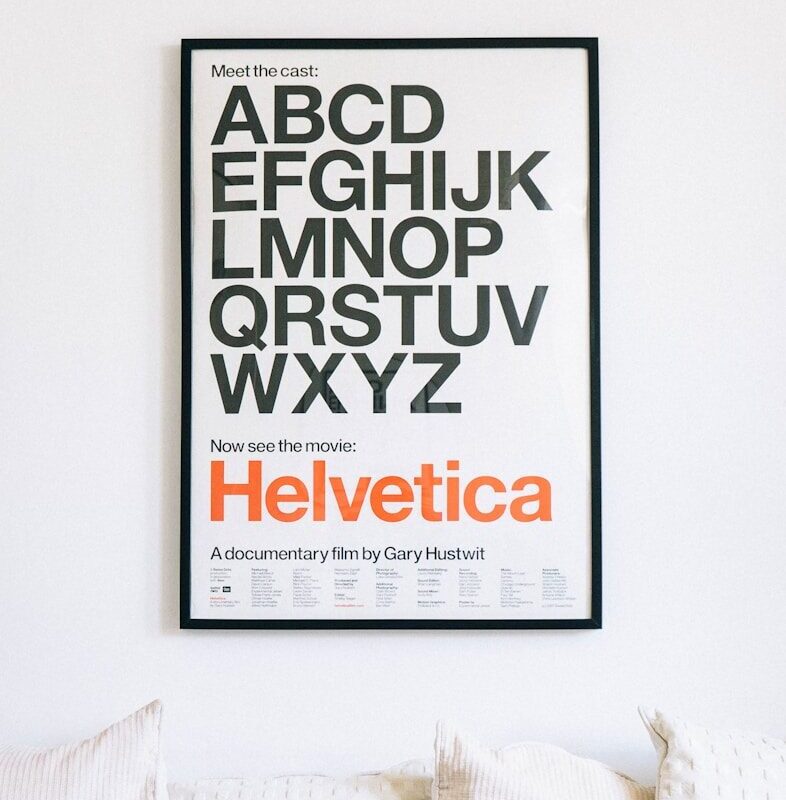 wall mounted Helvetica alphabet poster above sofa